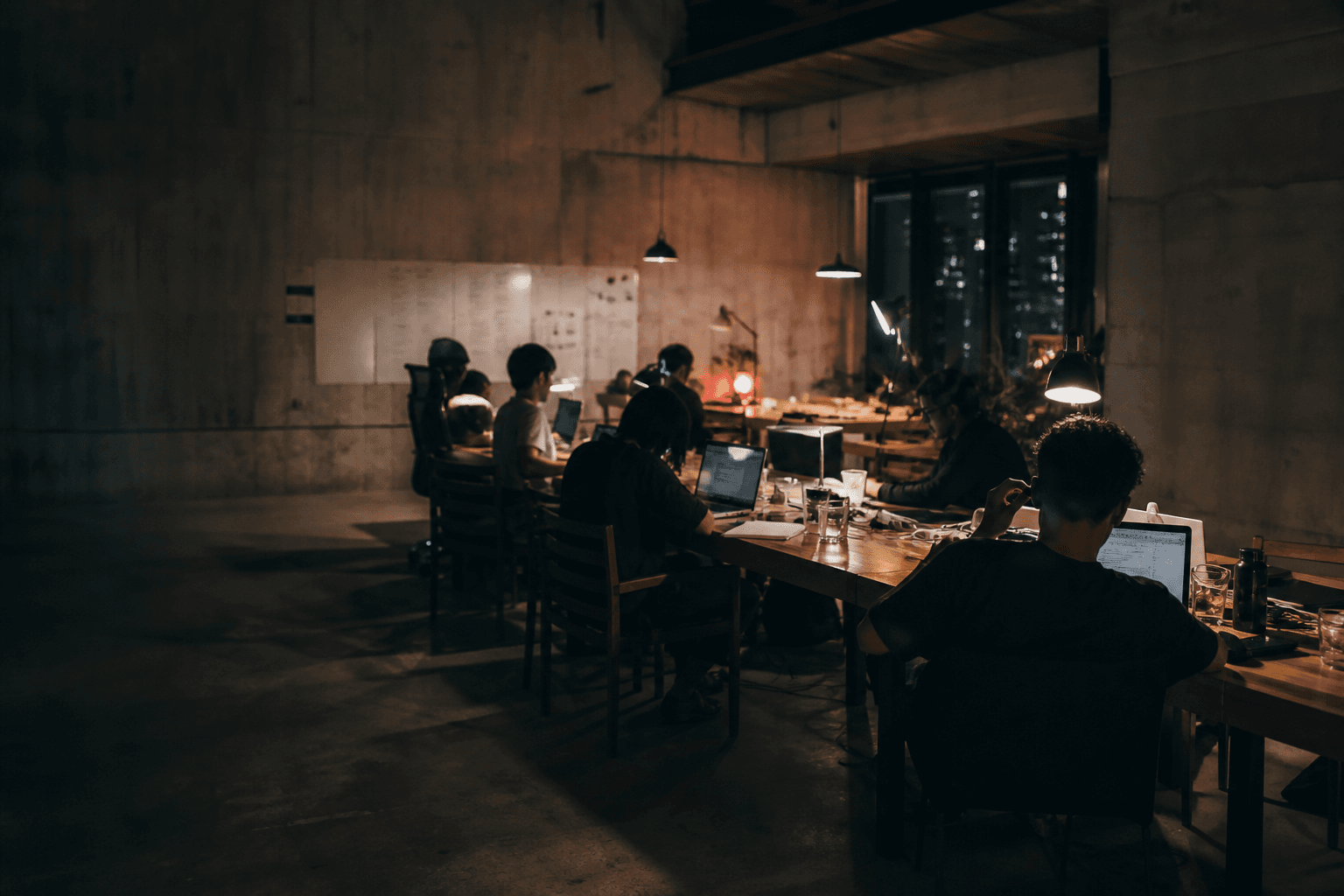 Builders working together around a long table at night
